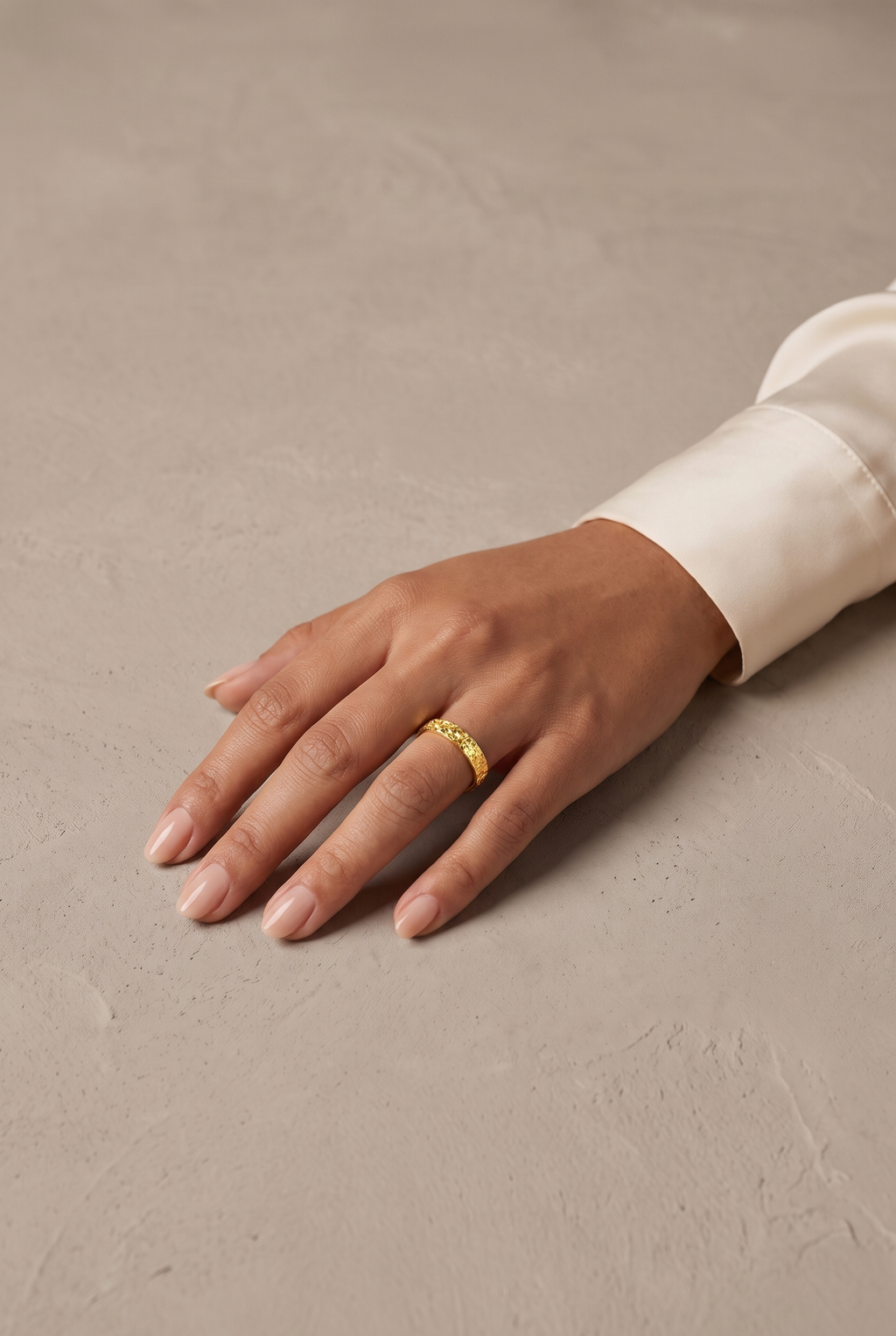 Sparkle-textured gold-tone band ring worn on the hand